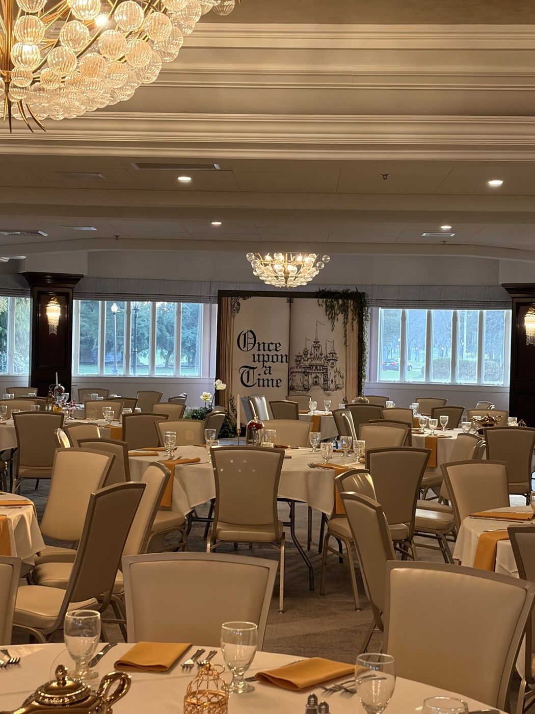 Elegant ballroom set for a formal banquet with round tables and chandeliers.