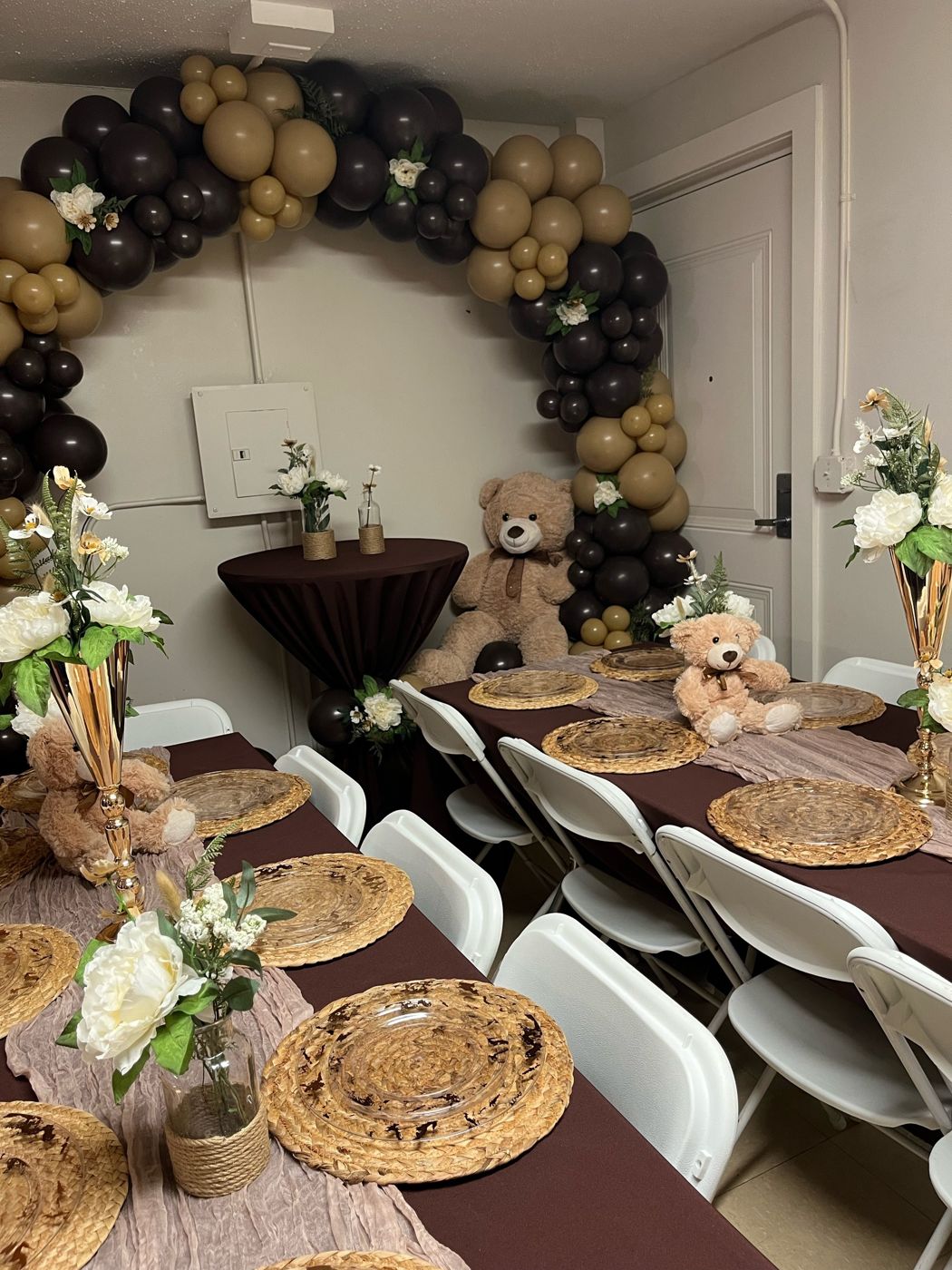 Black and gold balloon arch over a warm-toned tablescape for a mitzvah.