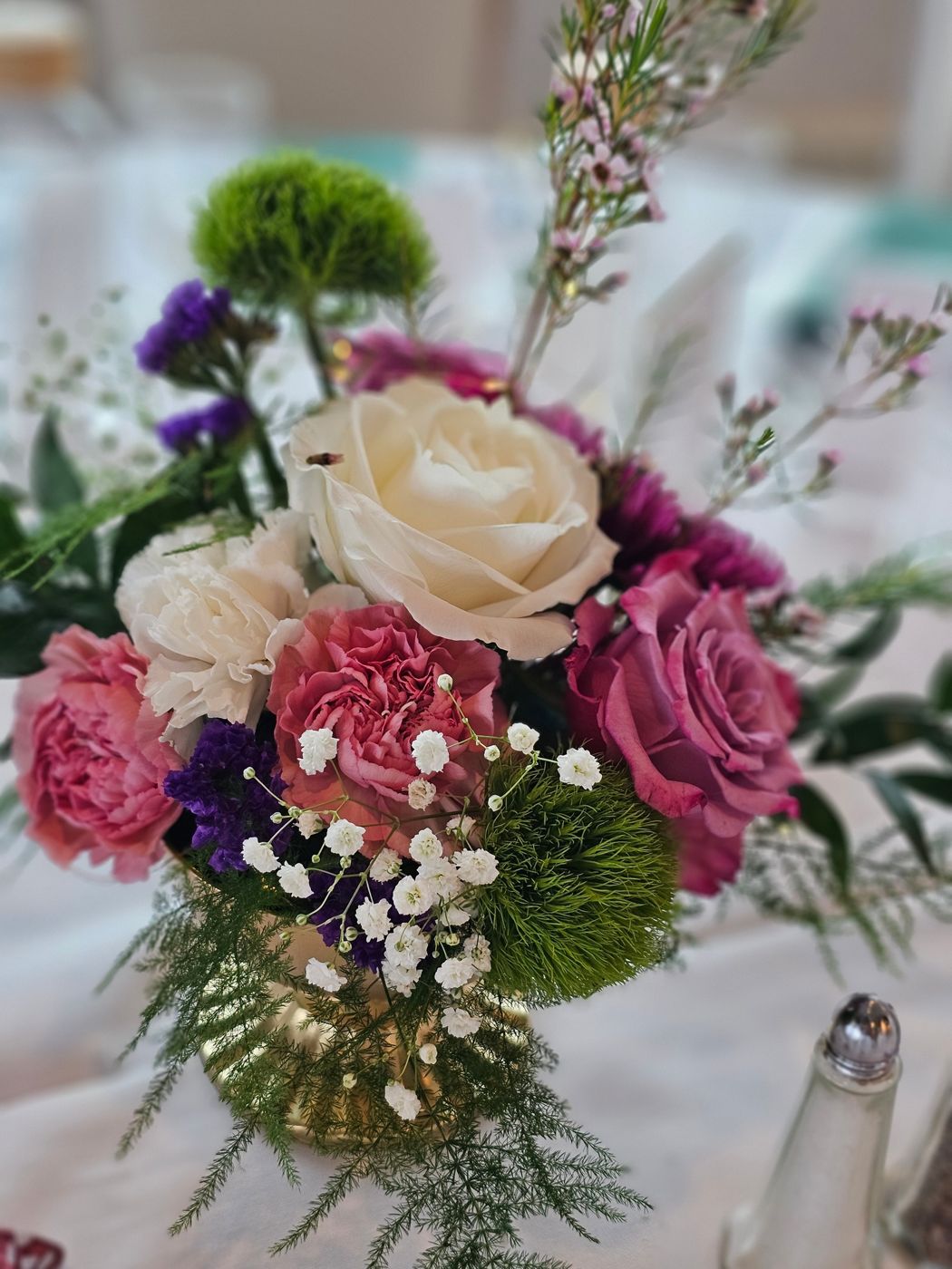 A lush bouquet of blush and burgundy roses with greenery, styled by Weston Events.